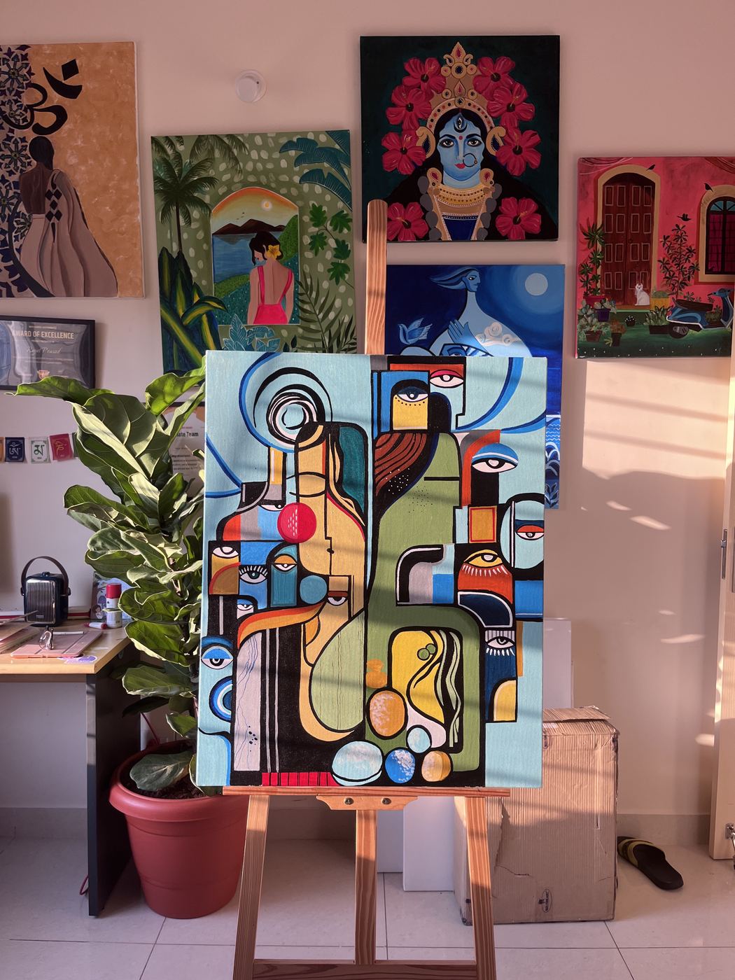 Paintings gathered on a shelf in the studio