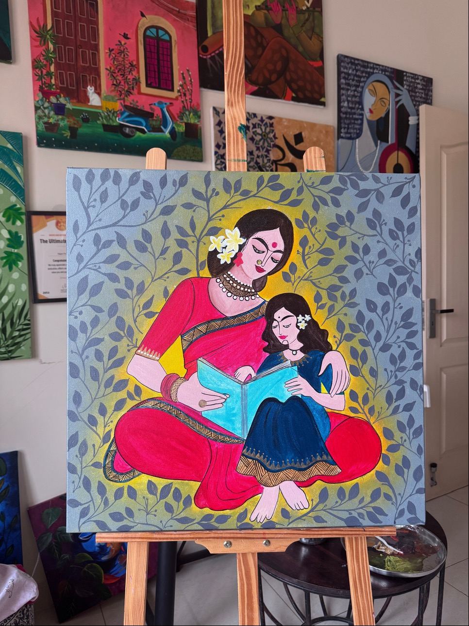 A mother and child painting on an easel