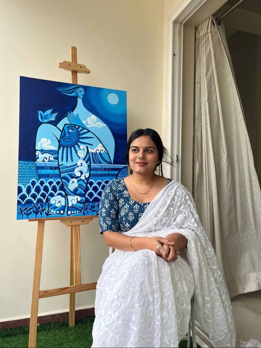 Rucha standing beside a blue painting on an easel
