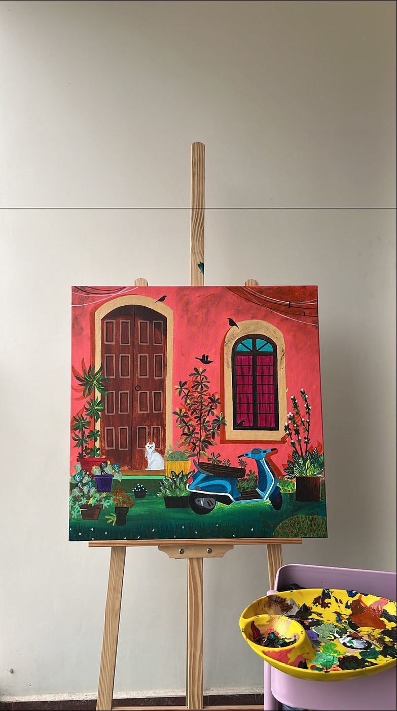 A red doorway painting resting on an easel