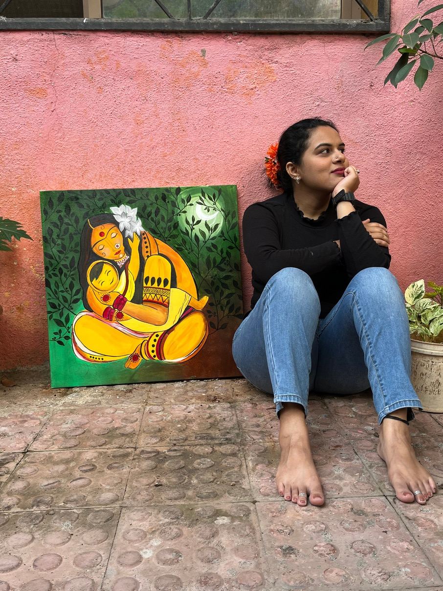 Rucha seated beside a green and gold painting